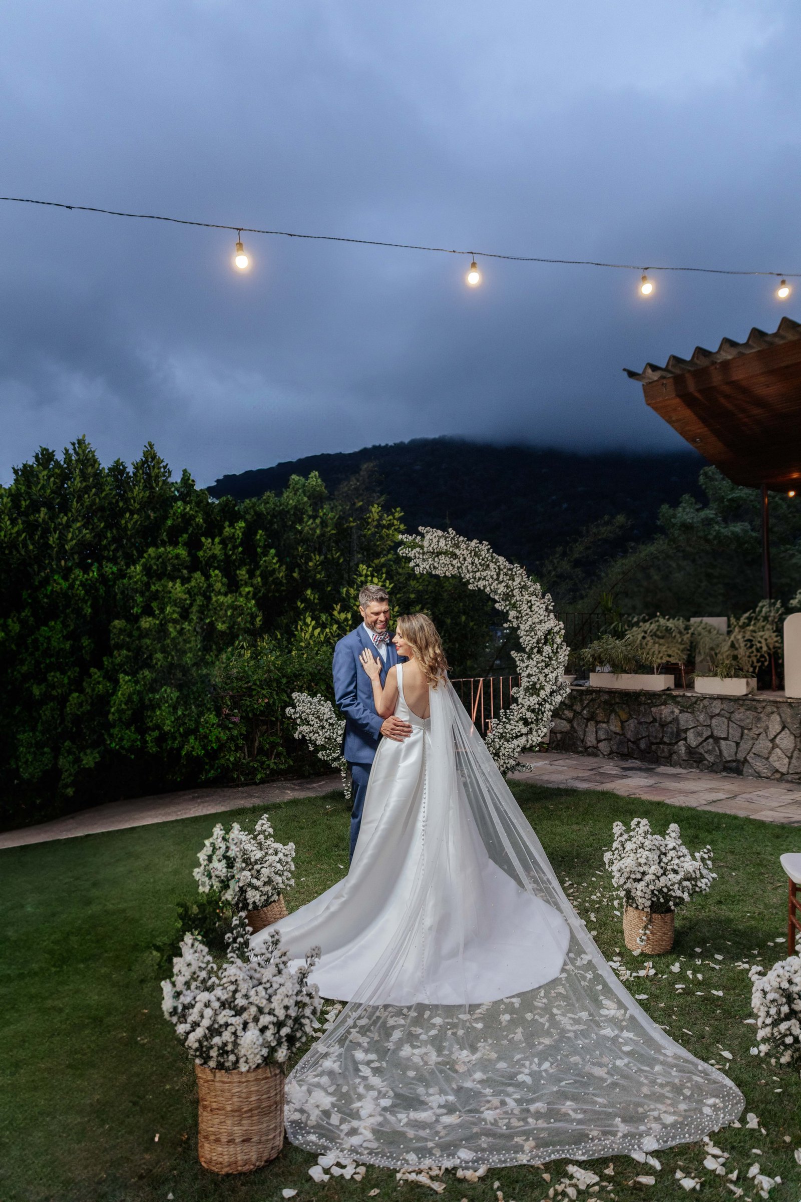 Couple under floral arch at night, destination wedding Rio de Janeiro